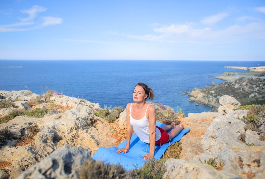 Mujer practicando yoga al aire libre, fomentando la relajación durante el tratamiento de FIV en verano.