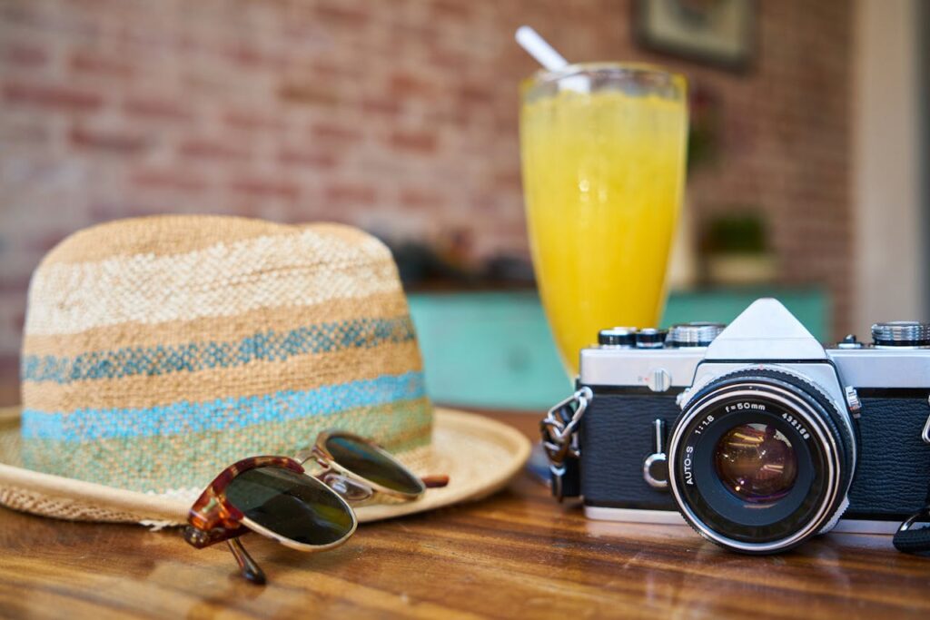 Cámara Réflex Digital Gris Y Negra Junto A Sombrero Para El Sol Y Gafas De Sol para saber cómo afrontar tu FIV en verano