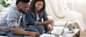 happy couple reviewing figures on laptop