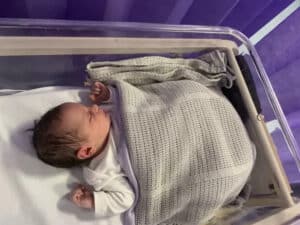 Newborn baby in hospital bed