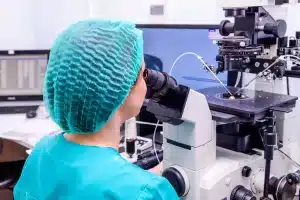 Doctor looking through microscope