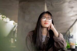 Woman in glasses looking thoughtful