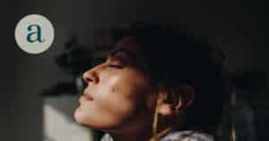 Woman with eyes closed smiling in sun beam