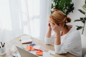 Lady with head in her hands looking at receipts and calculator